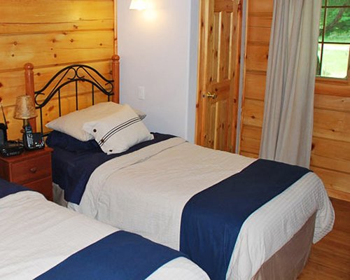 A well furnished bedroom with two twin beds and an outside view.