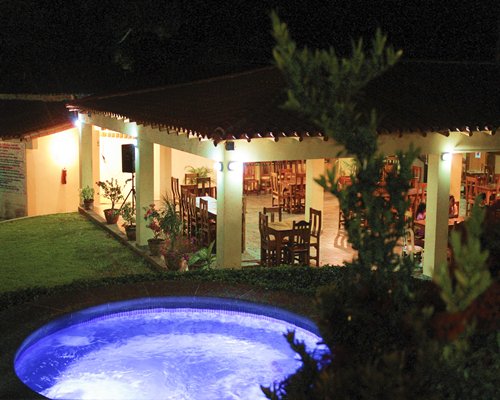 An outdoor hot tub alongside the resort at night.