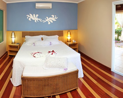 A well furnished bedroom with two lamps and an outside view.