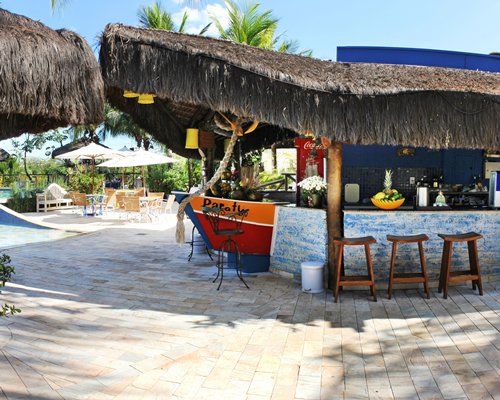 An outdoor well equipped bar alongside patio and sunshades.