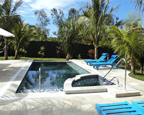 An outdoor swimming pool with chaise lounge chairs.