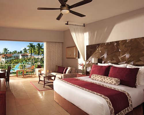 A well furnished bedroom with patio furniture and an outside view.