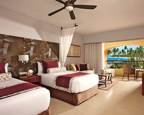 A well furnished bedroom and living area with a television and a patio.