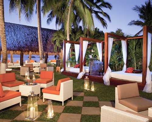 Lounge area with beach beds and palm trees.