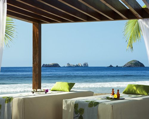 Covered outdoor spa with massage beds alongside the beach.