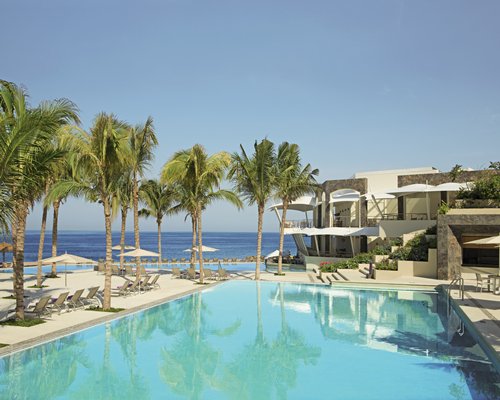 An outdoor swimming pool with chaise lounge chairs.
