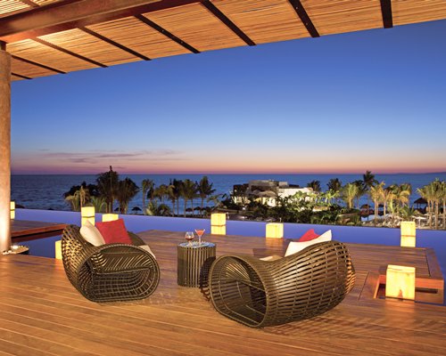 A well furnished lounge area with the ocean view at dusk.