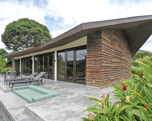 Exterior view of a unit with an outdoor patio and chaise lounge chairs.