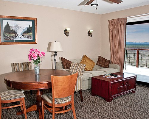 A well furnished living room with a dining area and balcony.