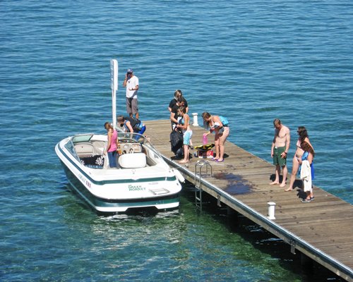 People on a wooden pier and boat outside of the resort.