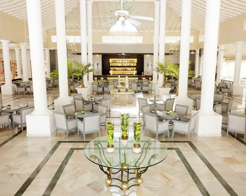 A well equipped bar alongside dining area with multiple tables.