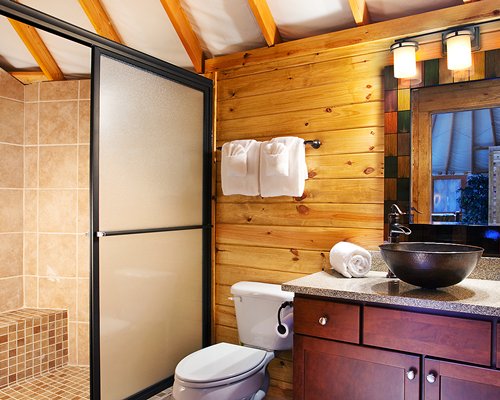 A bathroom with shower and single sink vanity.