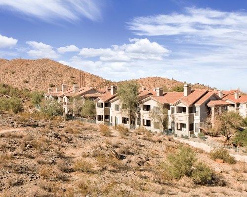 AN EXTERIOR VIEW OF MULTI STORY RESORT UNITS WITH TREES.