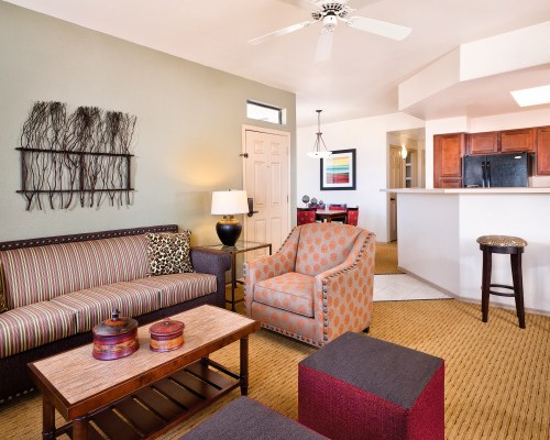 A WELL FURNISHED LIVING ROOM WITH DINING AREA OPEN PLAN KITCHEN AND A BREAKFAST BAR.