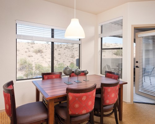 WOODEN DINING AREA WITH AN OUTSIDE VIEW.