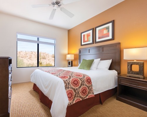 A WELL FURNISHED BEDROOM WITH AN OUTSIDE VIEW.