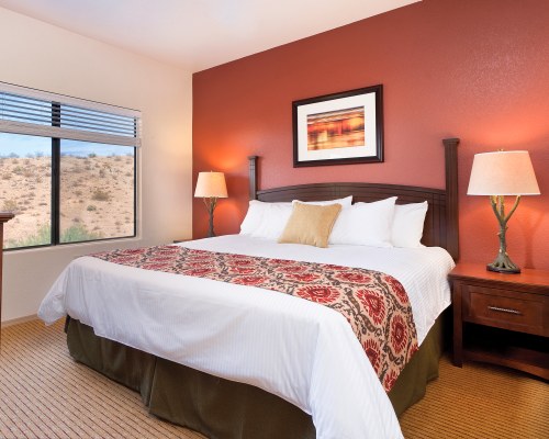A WELL FURNISHED BEDROOM WITH AN OUTSIDE VIEW.