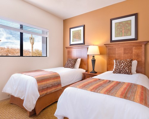 A WELL FURNISHED BEDROOM WITH TWO QUEEN BEDS.
