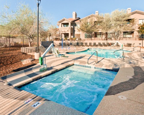 AN OUTDOOR SWIMMING POOL AND HOT TUB ALONGSIDE THE RESORT.