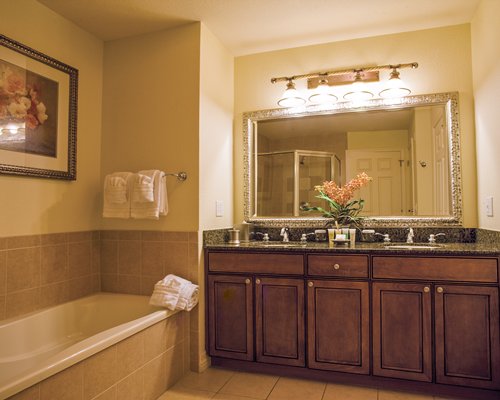 A bathroom with double sink vanity shower and bathtub.