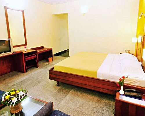 A well furnished bedroom with a television and dresser.