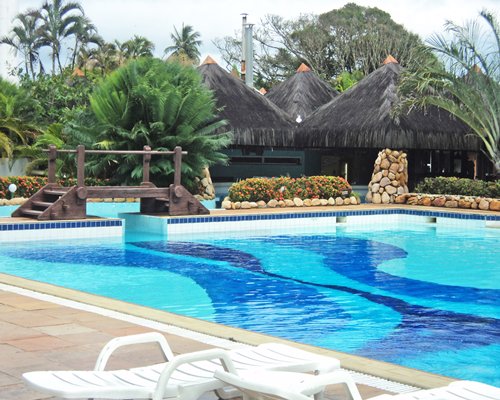 Outdoor swimming pool with a bridge and chaise lounge chairs.