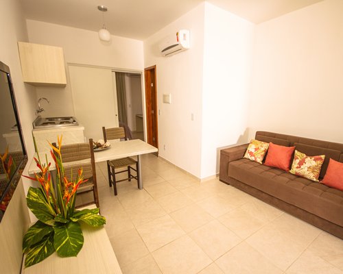 Living room with a television dining table and open plan kitchen.