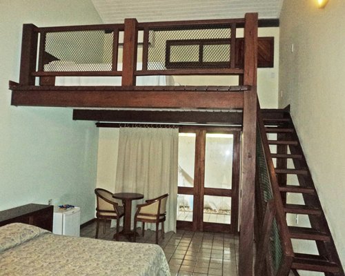 A well furnished bedroom with an indoor balcony.