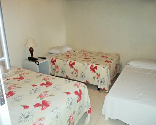 A well furnished bedroom with three beds.