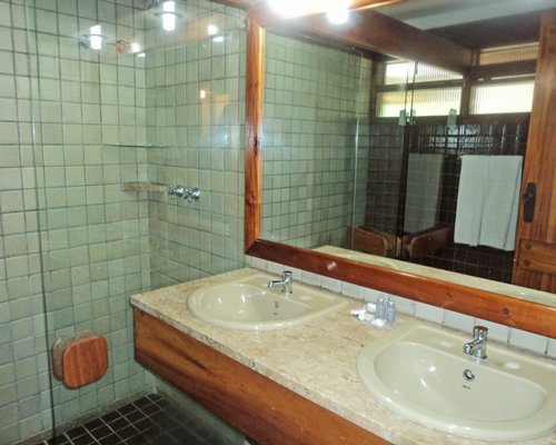 A bathroom with stand up shower and double sink vanity.