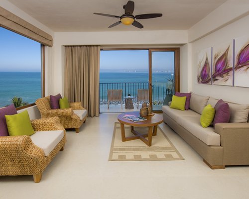 A well furnished living room with a pull out sofa and a balcony.