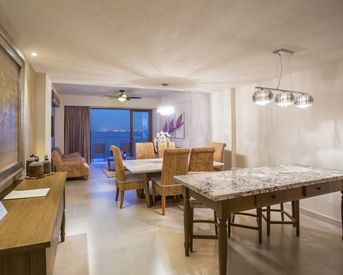 A well furnished living room with a dining area balcony and patio furniture.