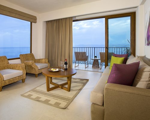 A well furnished living room with a pull out sofa and a balcony.