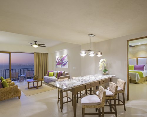 A well furnished living room with a dining area alongside bedroom.