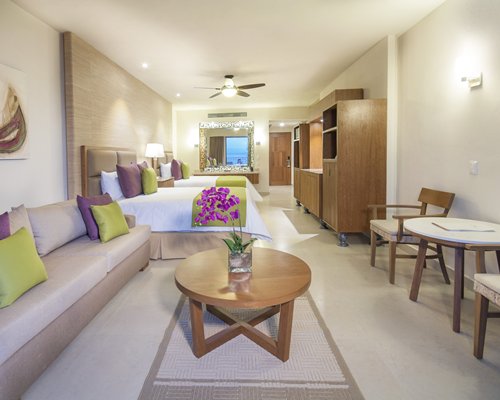 A well furnished bedroom with two twin beds and dining area.