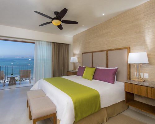 A well furnished bedroom with a balcony and patio furniture.