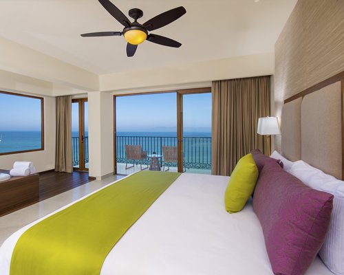 A well furnished bedroom with a balcony.