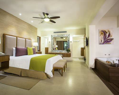 A well furnished large bedroom with a bathtub.