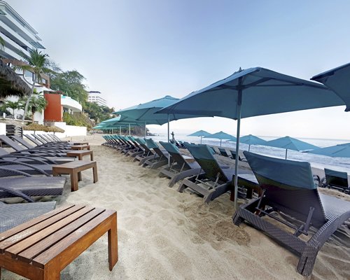 View of chaise lounge chairs and sunshades alongside the resort.