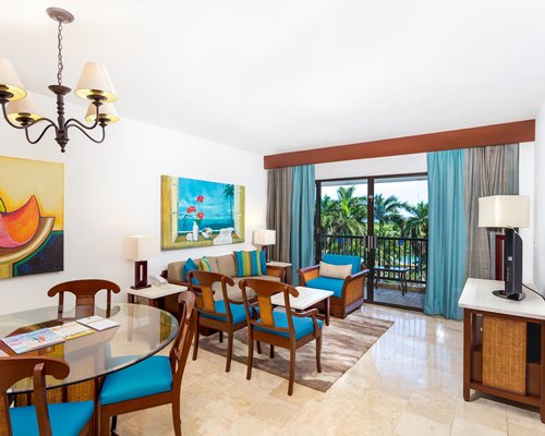 A well furnished living room with a television and balcony.