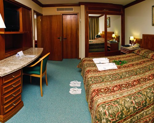 A well furnished living room with king bed and television.