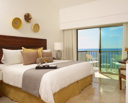 A well furnished bedroom with a balcony.