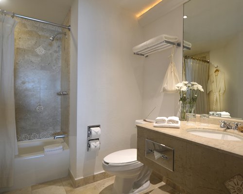 A bathroom with shower bathtub and a single sink vanity.