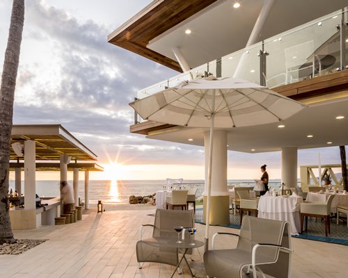 An outdoor fine dining restaurant alongside the ocean.