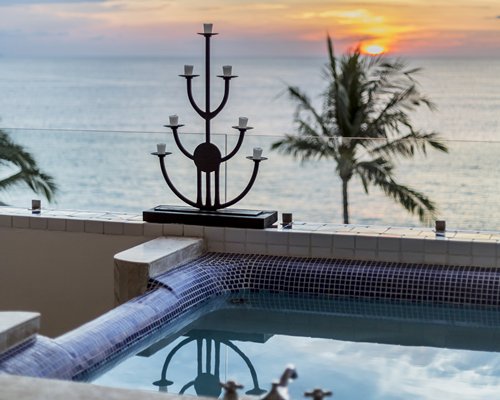 A view of the outdoor hot tub alongside the ocean at dusk.