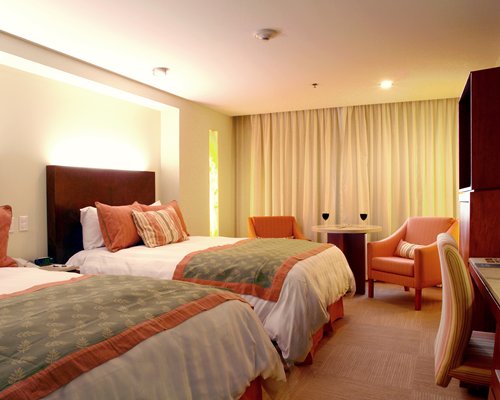 A well furnished bedroom with two double beds.