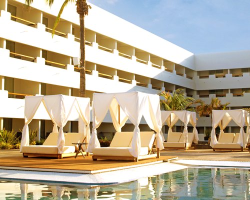 An outdoor swimming pool with cabana alongside the multi story unit.