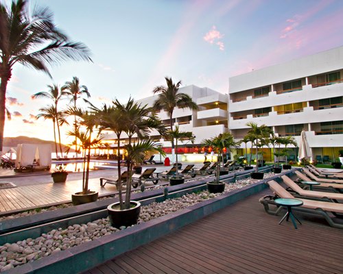 Exterior view of the Emporio Mazatlan with chaise lounge chairs at dusk.