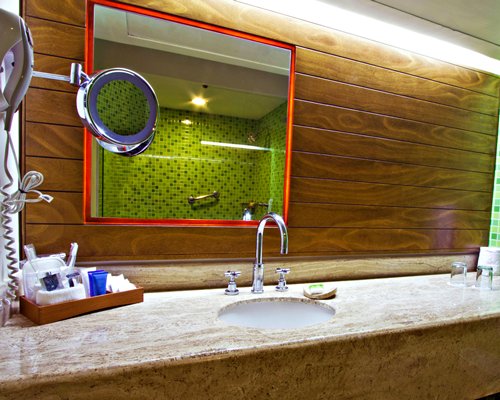 A bathroom with a stand up shower and single sink vanity.