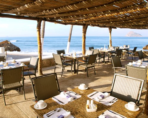 A well furnished indoor fine dining restaurant alongside the ocean.